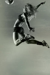Female basketball player jumping into air
